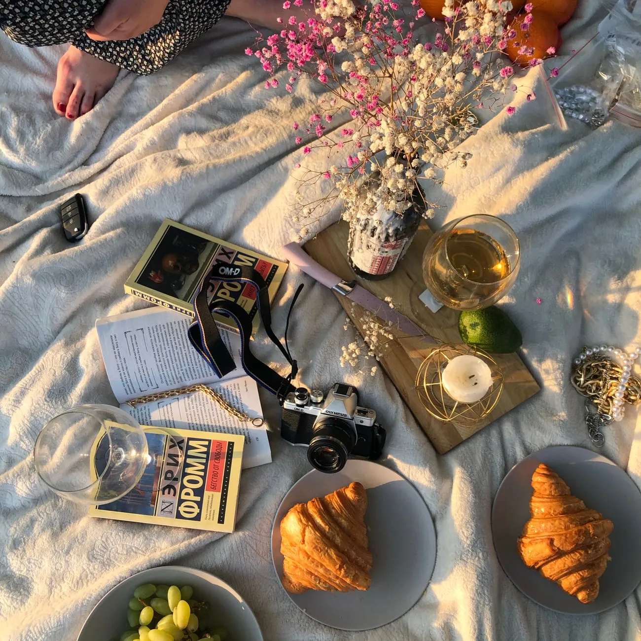 Buổi picnic nắng chiều với sách, cà phê và bánh sừng bò trên tấm khăn trải